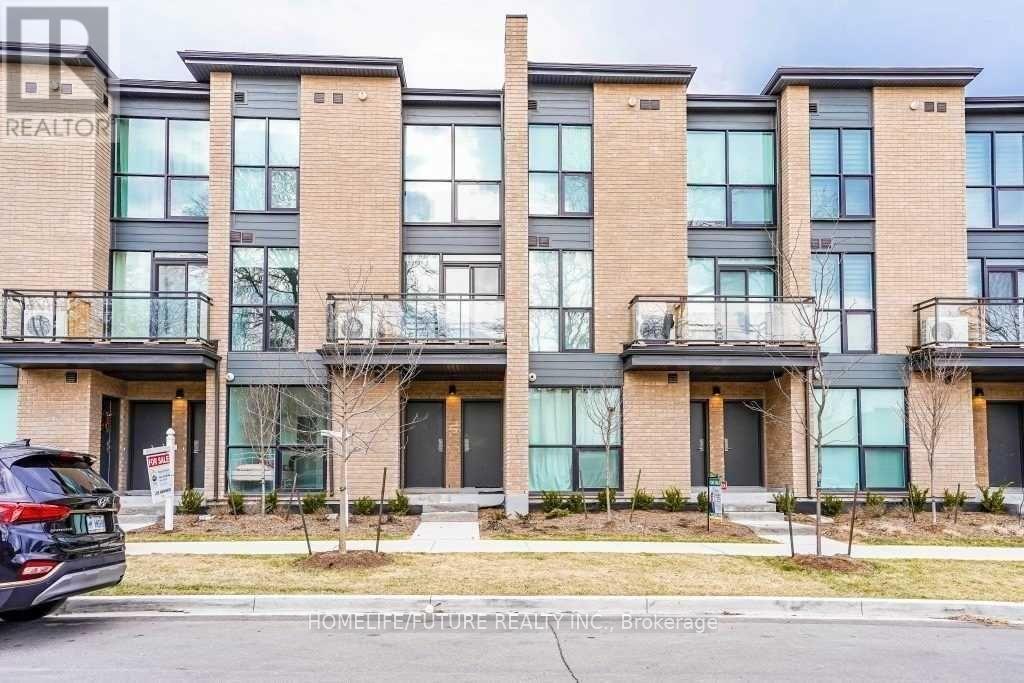 A modern apartment building with a car parked in front.
