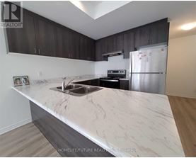 A kitchen with a marble countertop and stainless steel appliances.