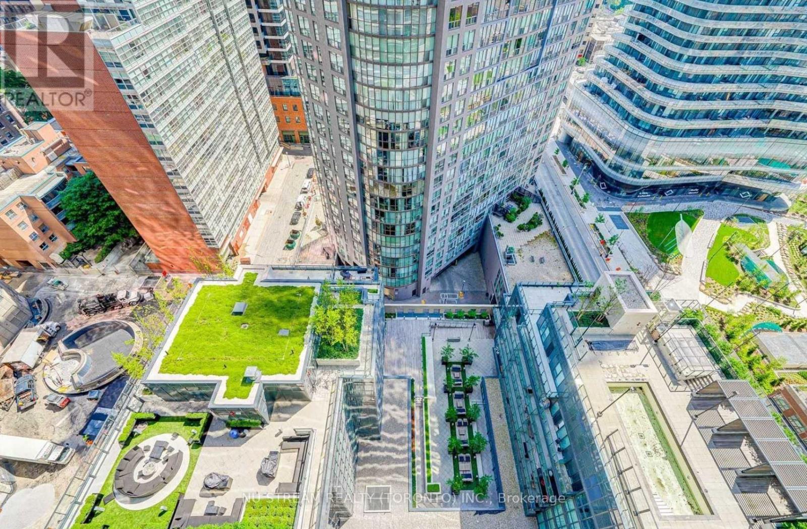 A bird's eye view of a city with tall buildings, roads, and green spaces.