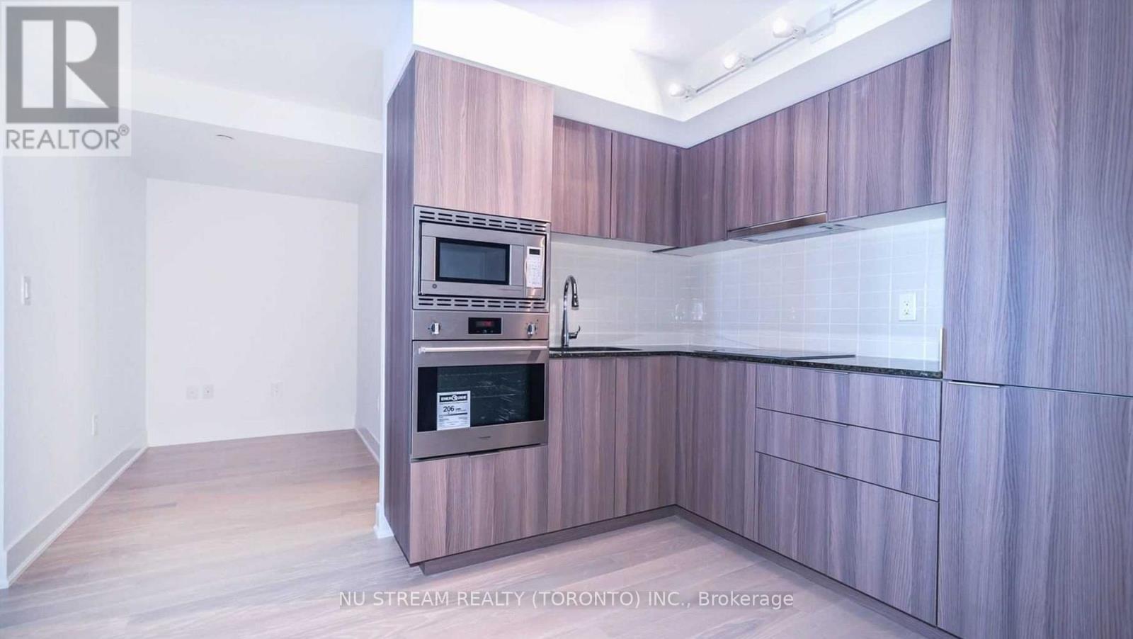 A kitchen with a microwave and oven built into the cabinetry.