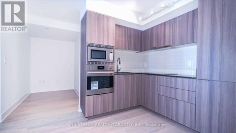 A kitchen with a microwave and oven built into the cabinetry.