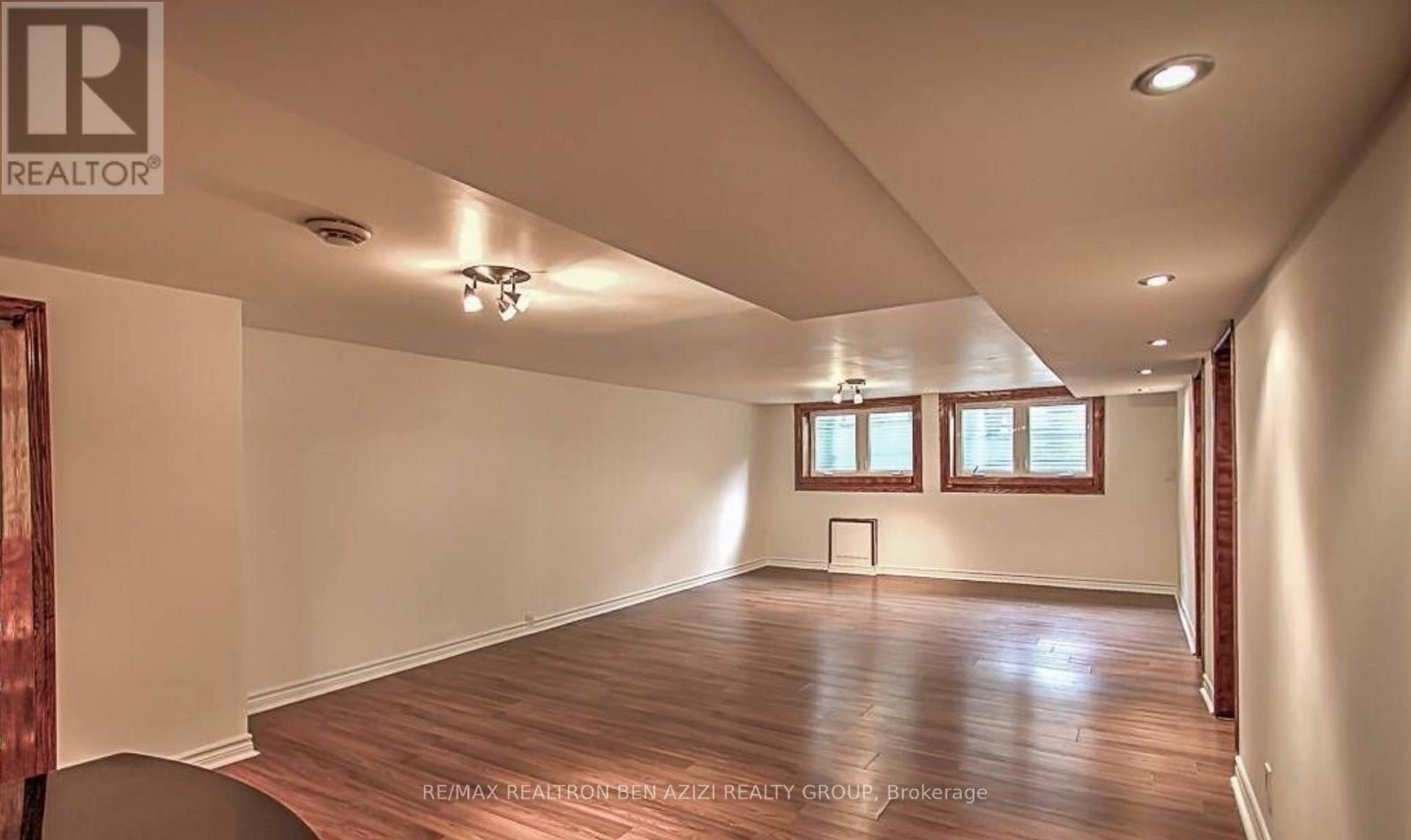 A spacious room with wooden floors and white walls.