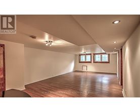 A spacious room with wooden floors and white walls.