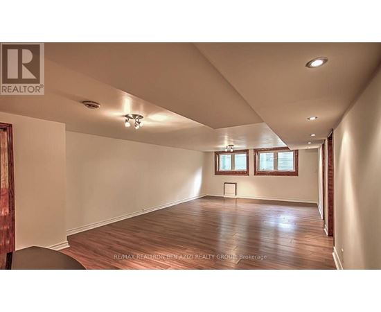 A spacious room with wooden floors and white walls.