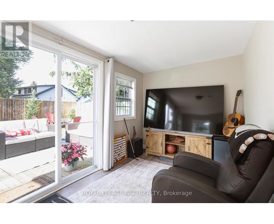 A living room with a television and a guitar on the wall.