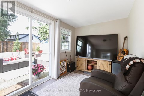 A living room with a television and a guitar on the wall.