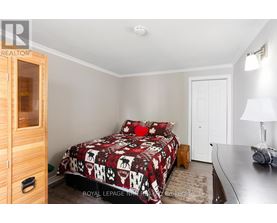 A bedroom with a bed covered in a red and white patterned bedspread.