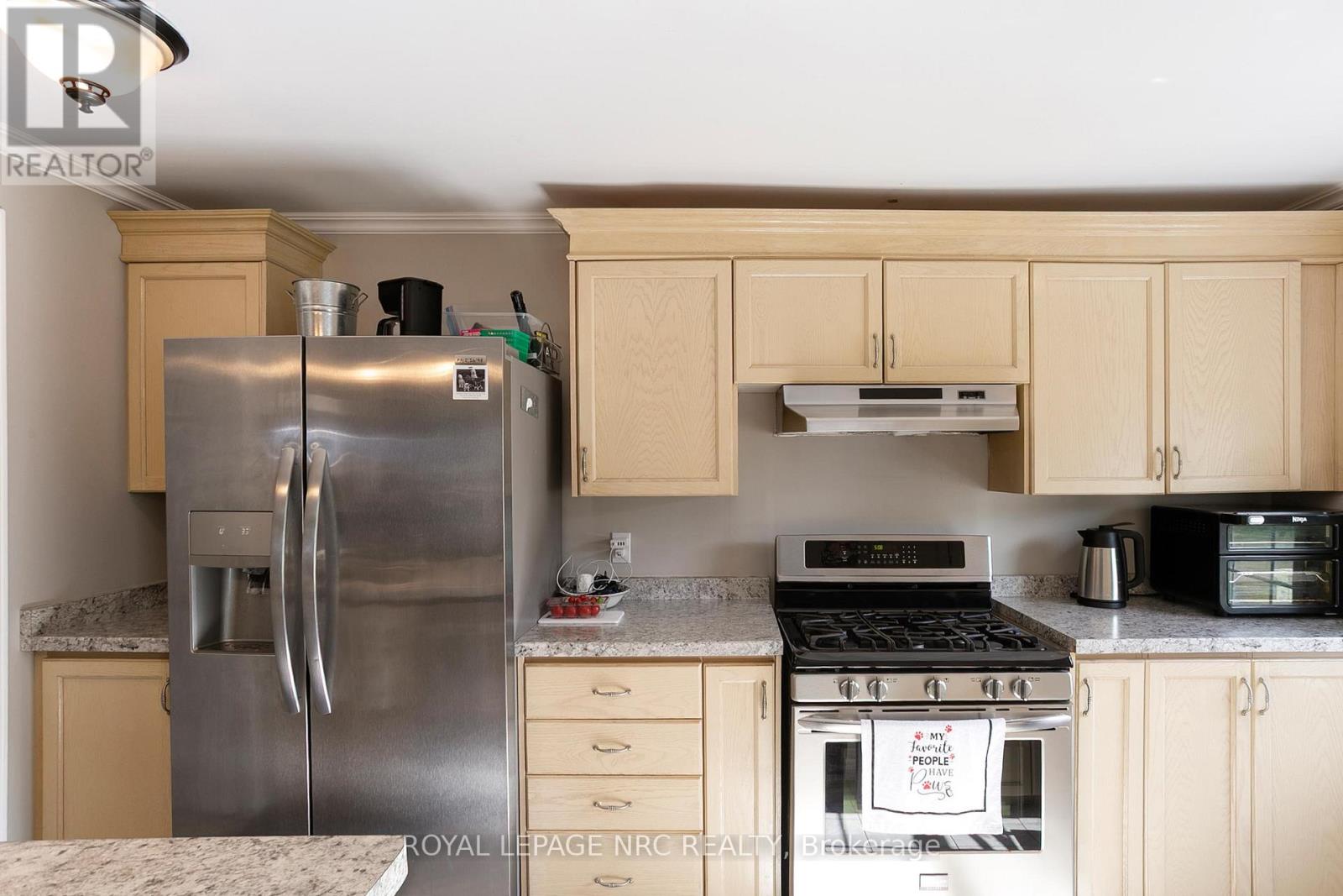 A kitchen with a stainless steel refrigerator and a white oven.