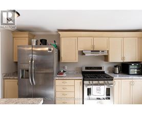 A kitchen with a stainless steel refrigerator and a white oven.