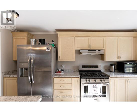 A kitchen with a stainless steel refrigerator and a white oven.