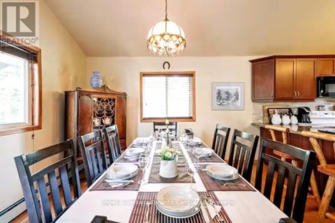 A dining room with a long table set for a meal.