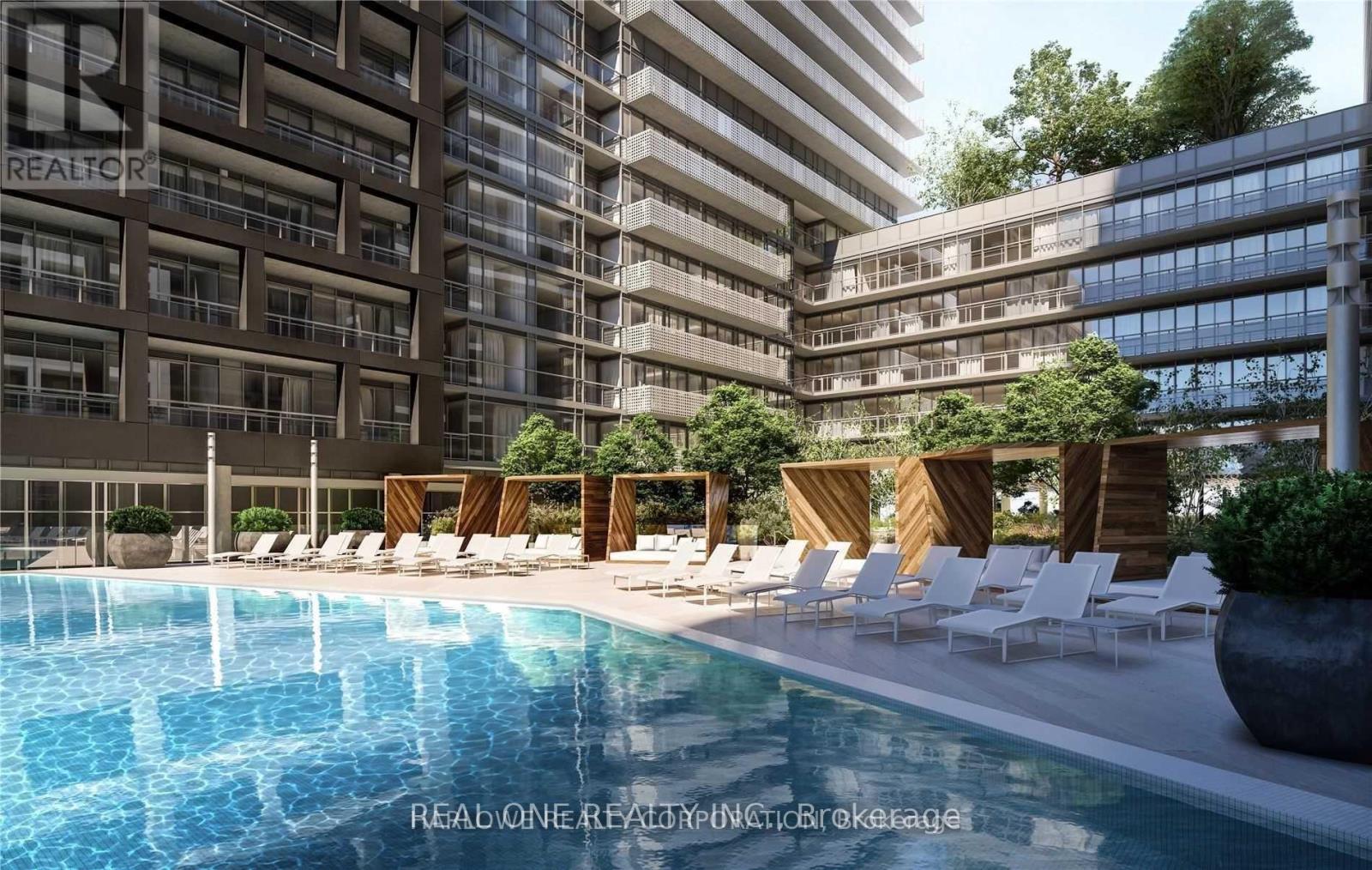 A pool area with lounge chairs and a building in the background.