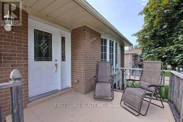 A patio with a white door and two chairs.