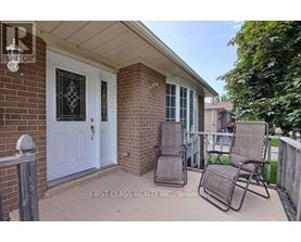 A patio with a white door and two chairs.