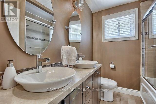 A bathroom with a large mirror and a white sink.