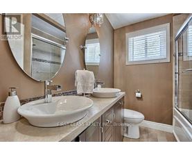 A bathroom with a large mirror and a white sink.