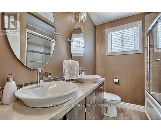 A bathroom with a large mirror and a white sink.
