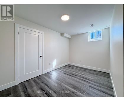 A room with a wooden floor and a window with white blinds.