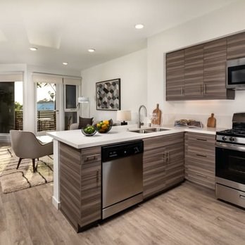 A modern kitchen with wooden cabinets and stainless steel appliances.