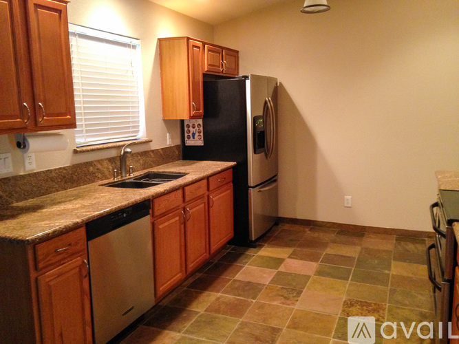 A kitchen with wooden cabinets and a black refrigerator.