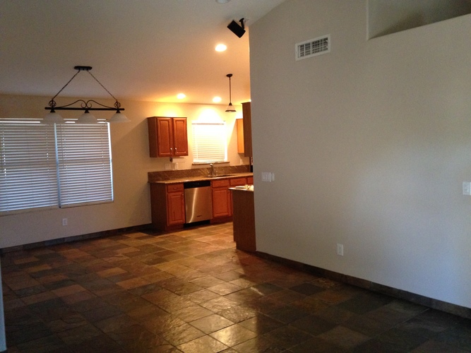 A kitchen with brown cabinets and a dining table.