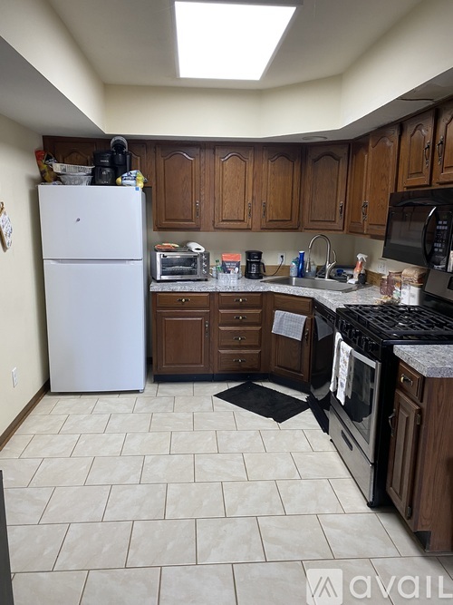 A kitchen with a white fridge and black countertops.