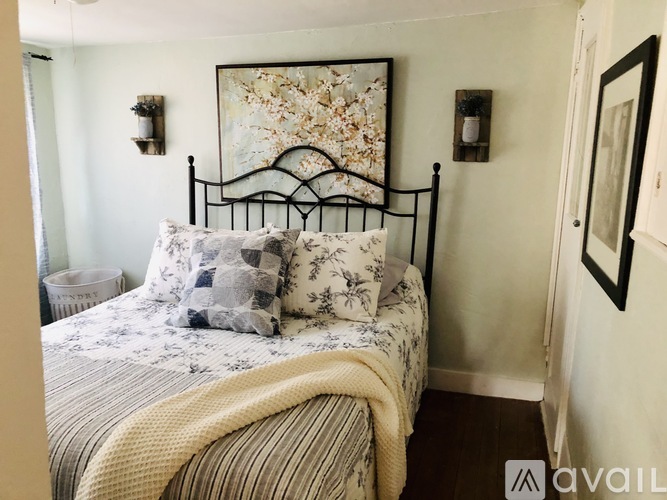 A bedroom with a large bed and a painting on the wall.
