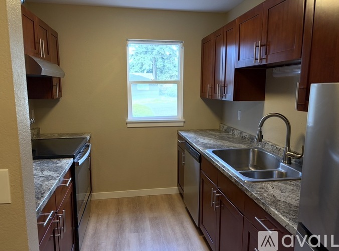 A kitchen with wooden cabinets and a window.
