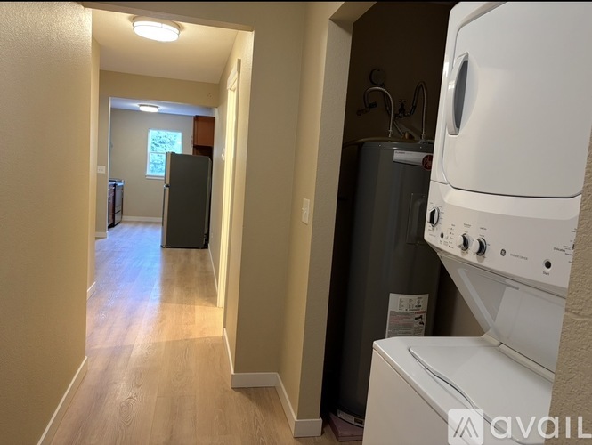 A hallway with a washer and dryer on the right side.