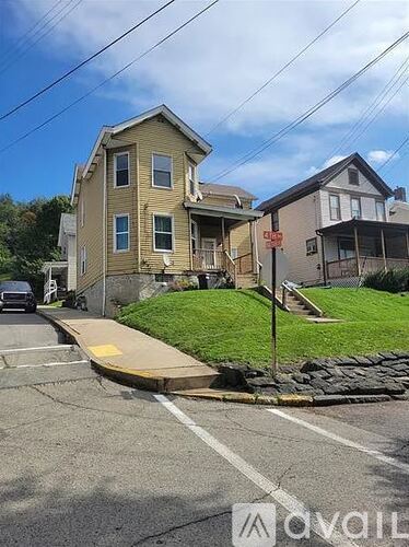 A yellow house with a red sign in front of it.