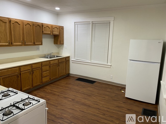 A kitchen with wooden cabinets and a white fridge.