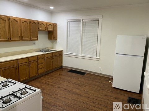 A kitchen with wooden cabinets and a white fridge.