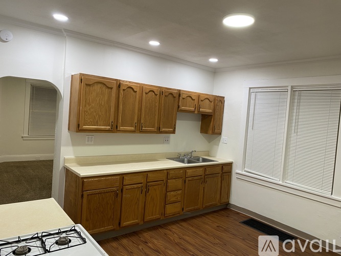 A kitchen with wooden cabinets and a white stove top.