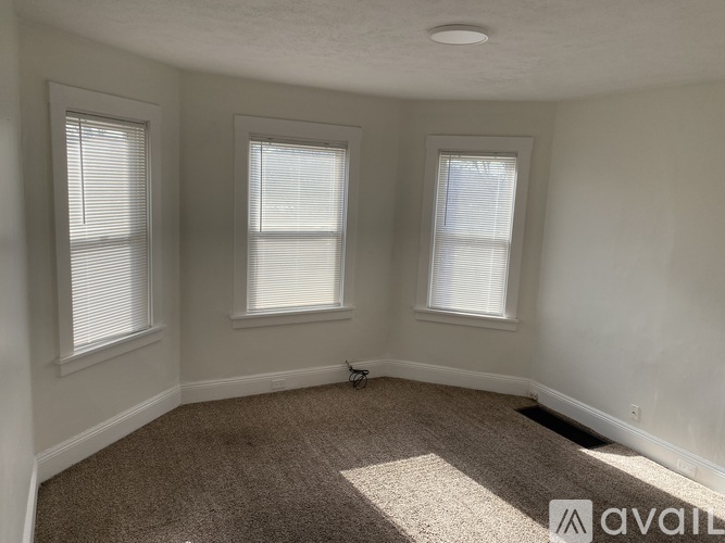 A room with two windows and carpeted floor.
