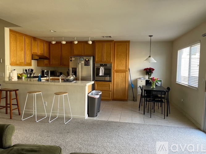 A kitchen with wooden cabinets and a dining table.