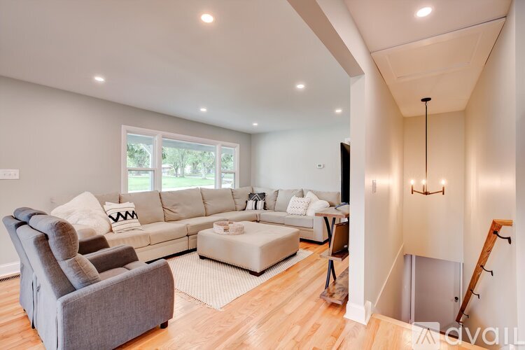 A living room with a grey couch and a white sofa.