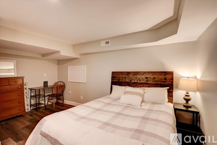 A bedroom with a large bed and a wooden headboard.