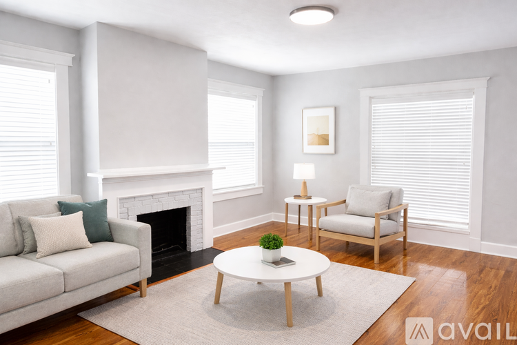A living room with a fireplace, a couch, a chair, and a coffee table.
