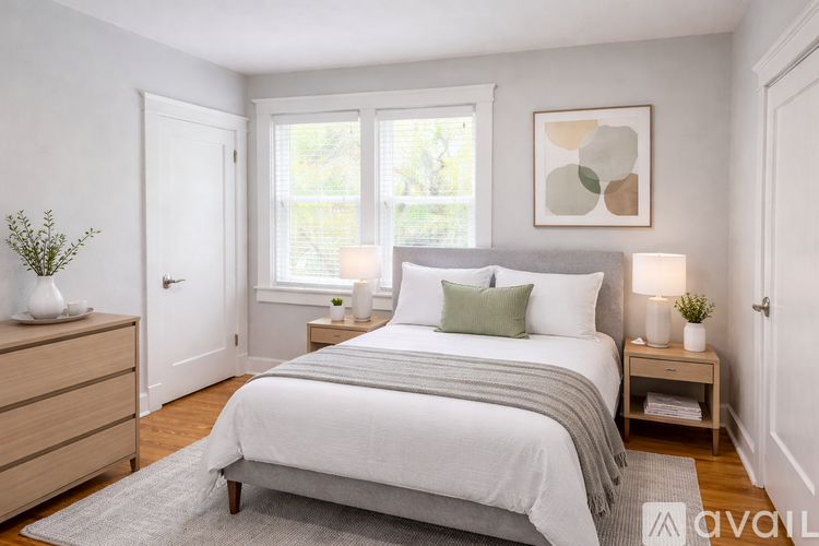 A bedroom with a large bed, a nightstand, and a window.