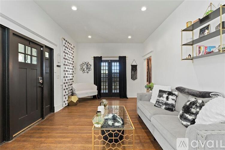 A living room with a white couch and a coffee table in the center.
