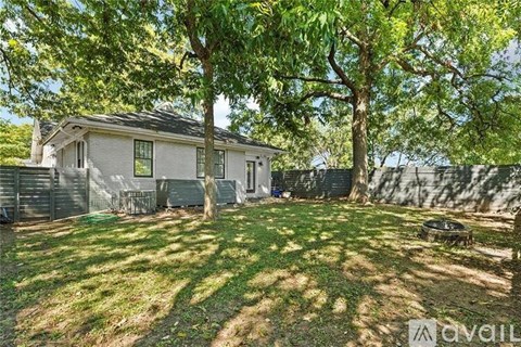 A house with a yard and trees in front of it.