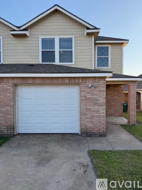 A house with a white garage door in front of it.