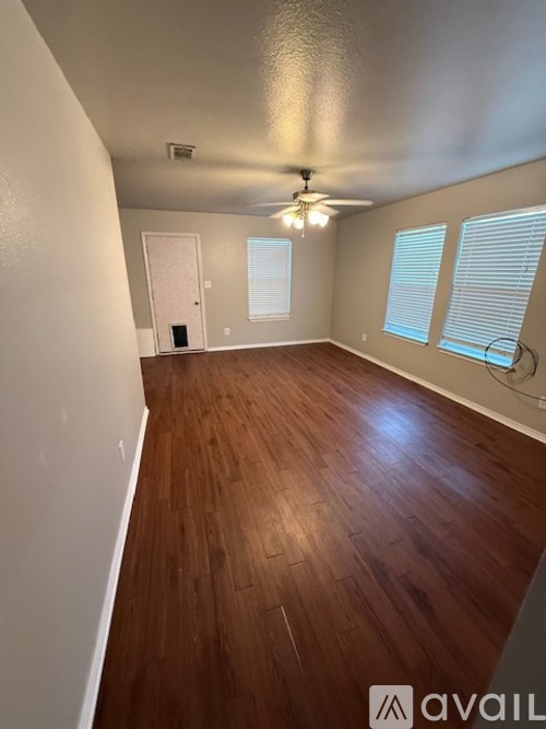 A room with wooden flooring and a ceiling fan.