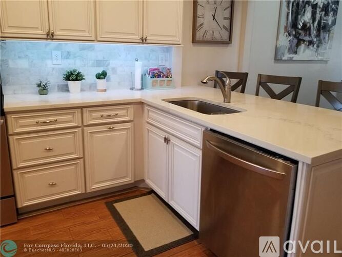 A kitchen with white cabinets and a stainless steel dishwasher.
