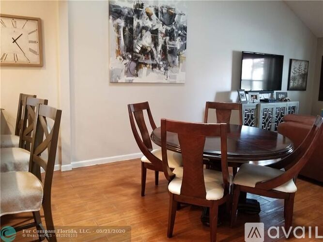 A dining room with a wooden table and chairs.
