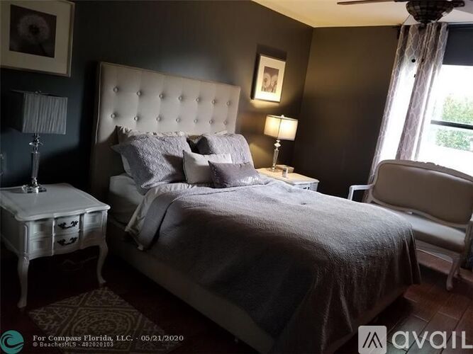 A bedroom with a large bed and a white nightstand.