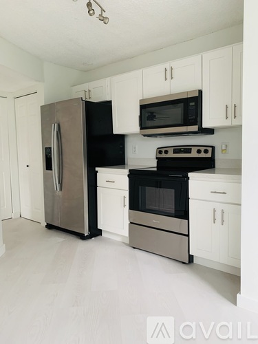 A kitchen with white cabinets and a black stove top oven.