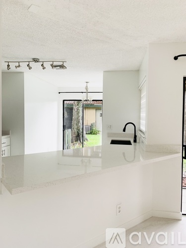 A white kitchen with a large island and a window.