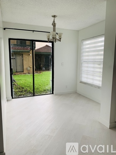 A room with a sliding glass door leading to a backyard.