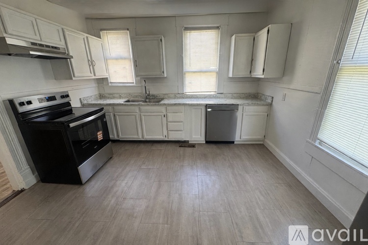 A kitchen with a black stove top oven and white cabinets.